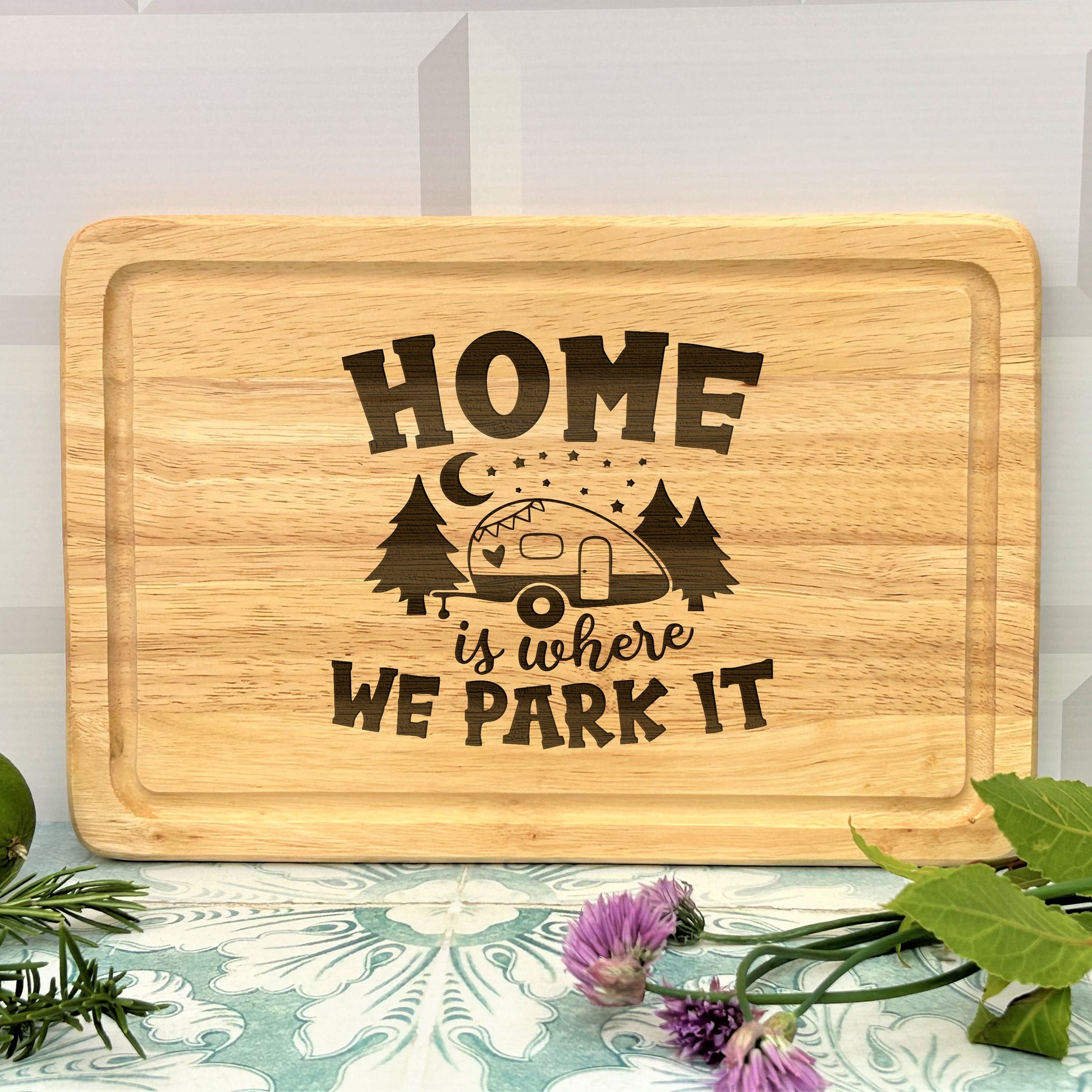 a wooden cutting board that says home is where we park it