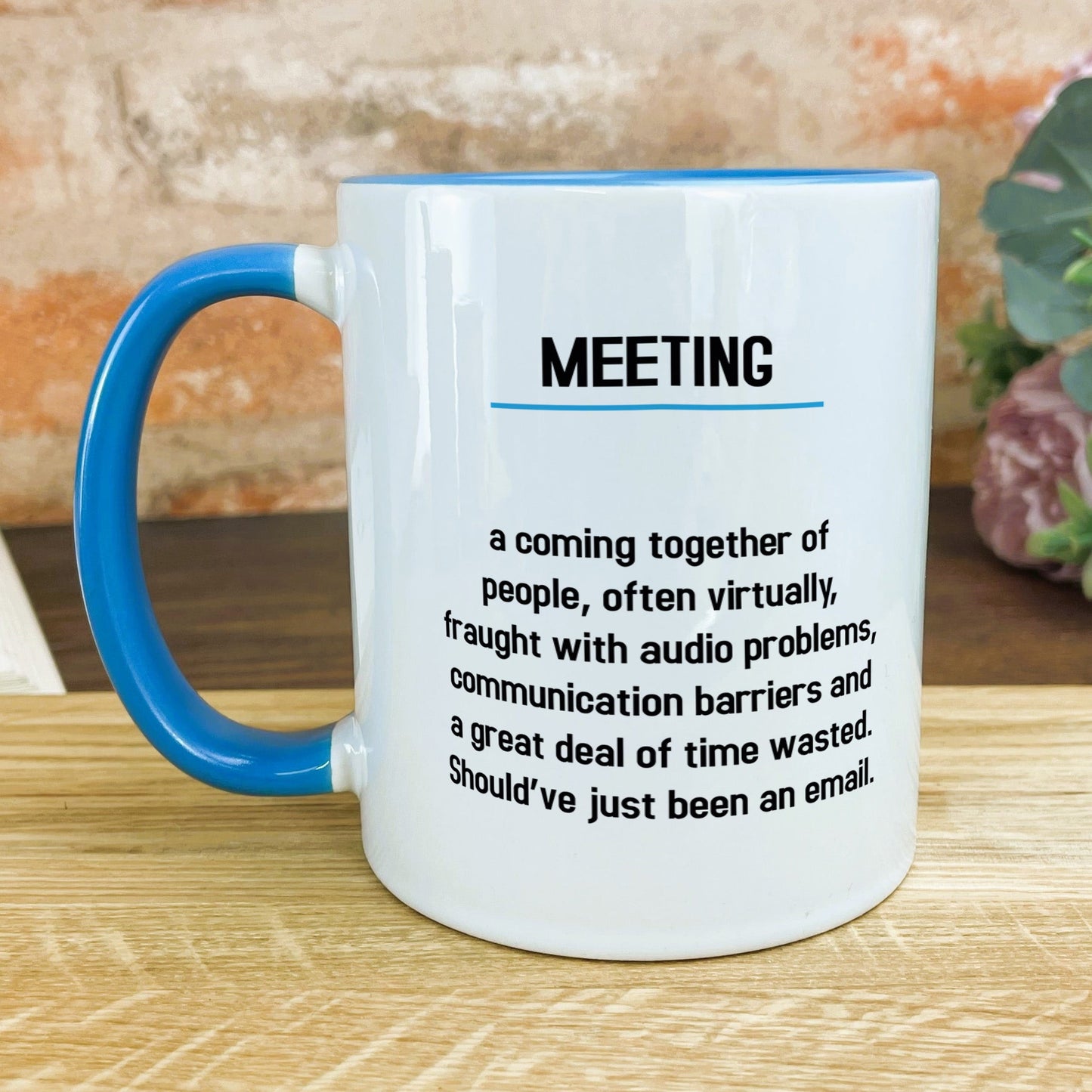 a blue and white coffee mug sitting on top of a wooden table