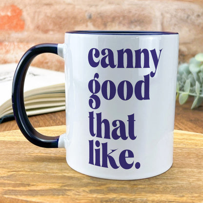 a black and white coffee mug sitting on top of a wooden table