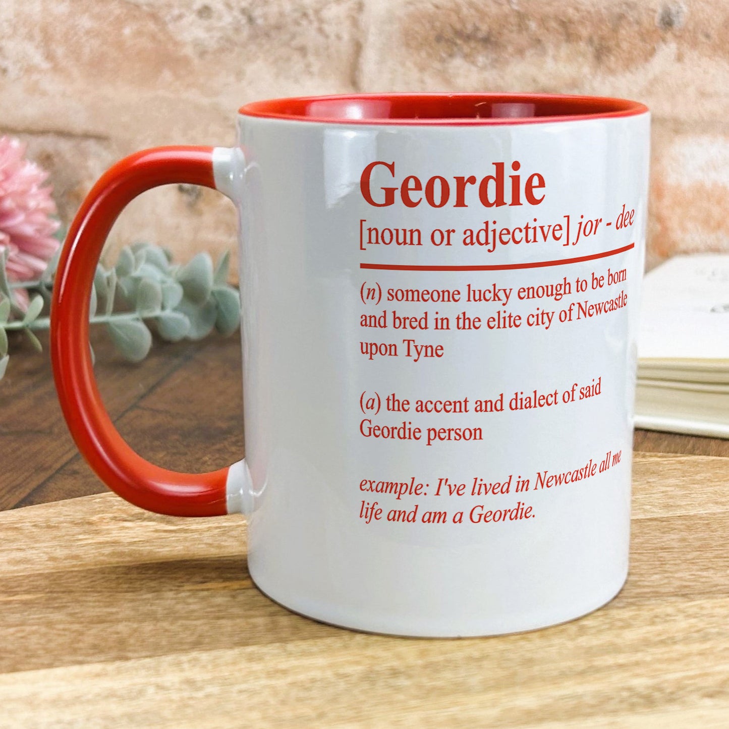 a red and white mug sitting on top of a wooden table