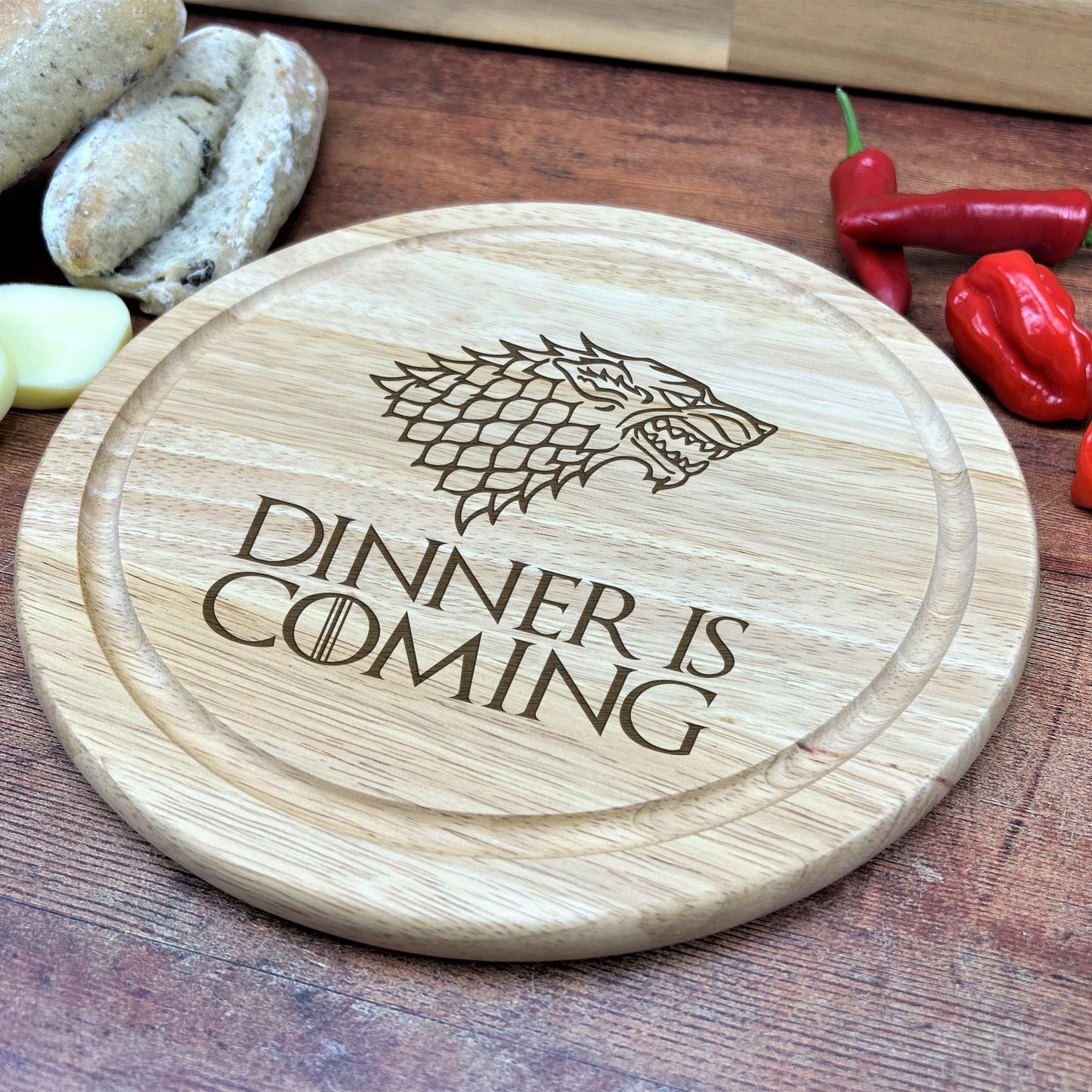 a wooden cutting board with a game of throne logo on it