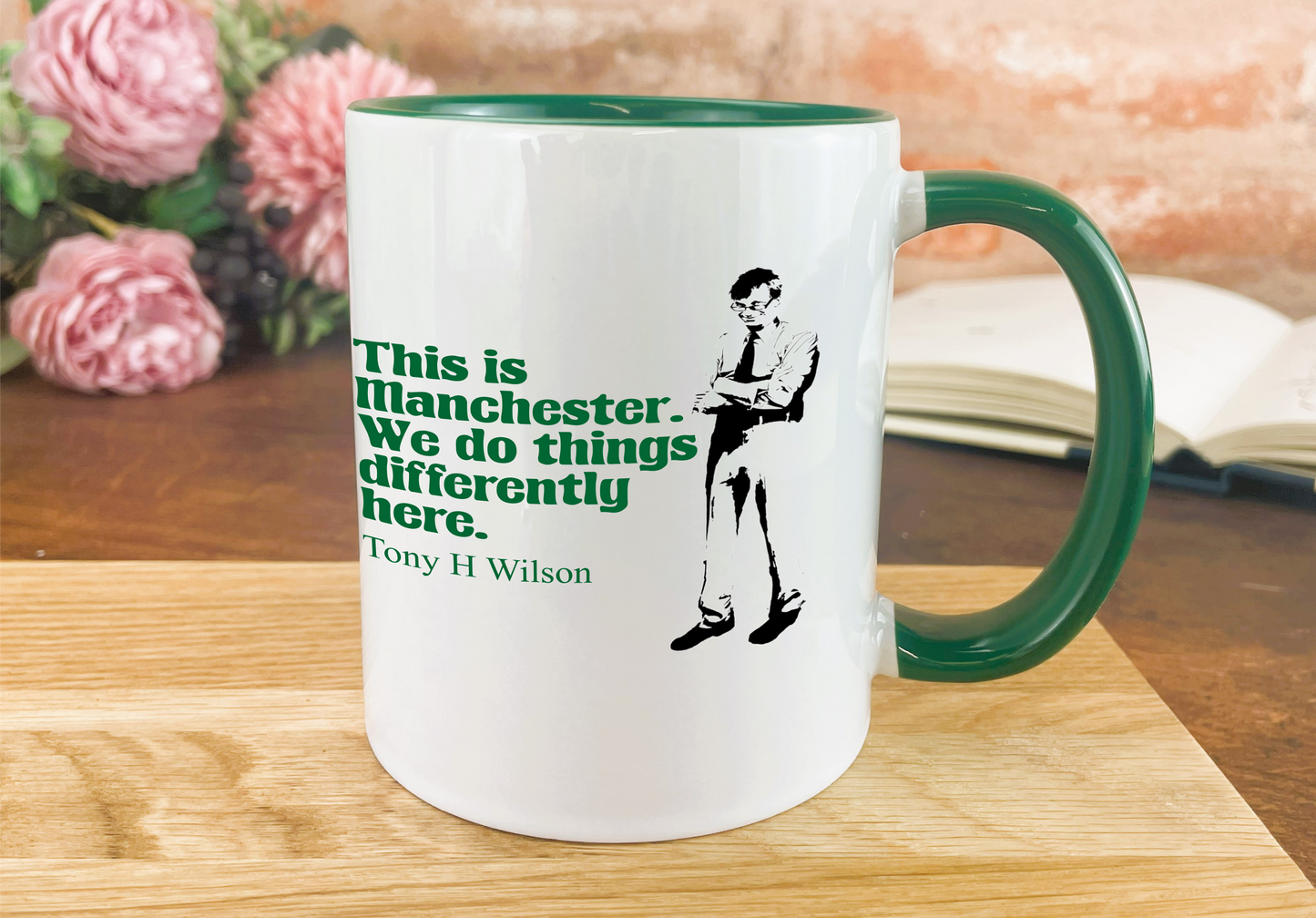 a green and white coffee mug sitting on top of a wooden table