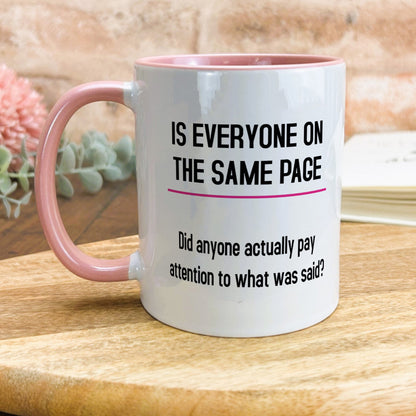 a pink and white coffee mug sitting on top of a wooden table