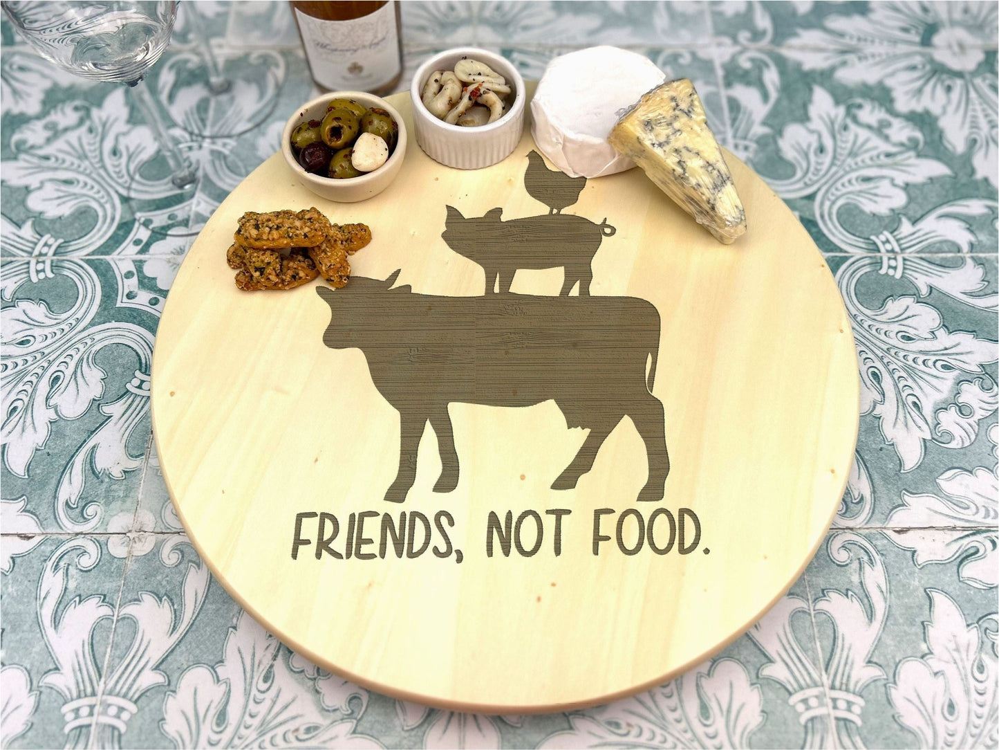 a wooden plate topped with a cow and a couple of bowls of food