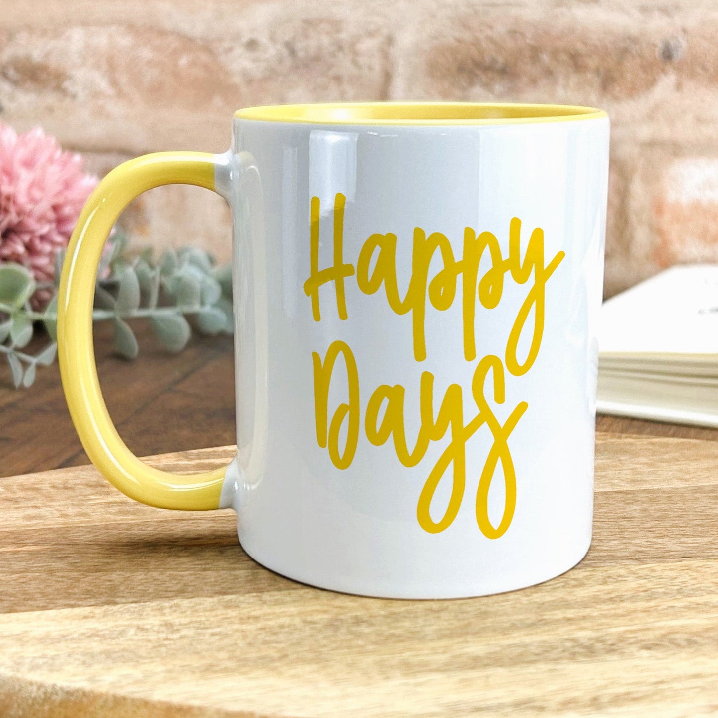 a yellow and white coffee mug sitting on top of a wooden table