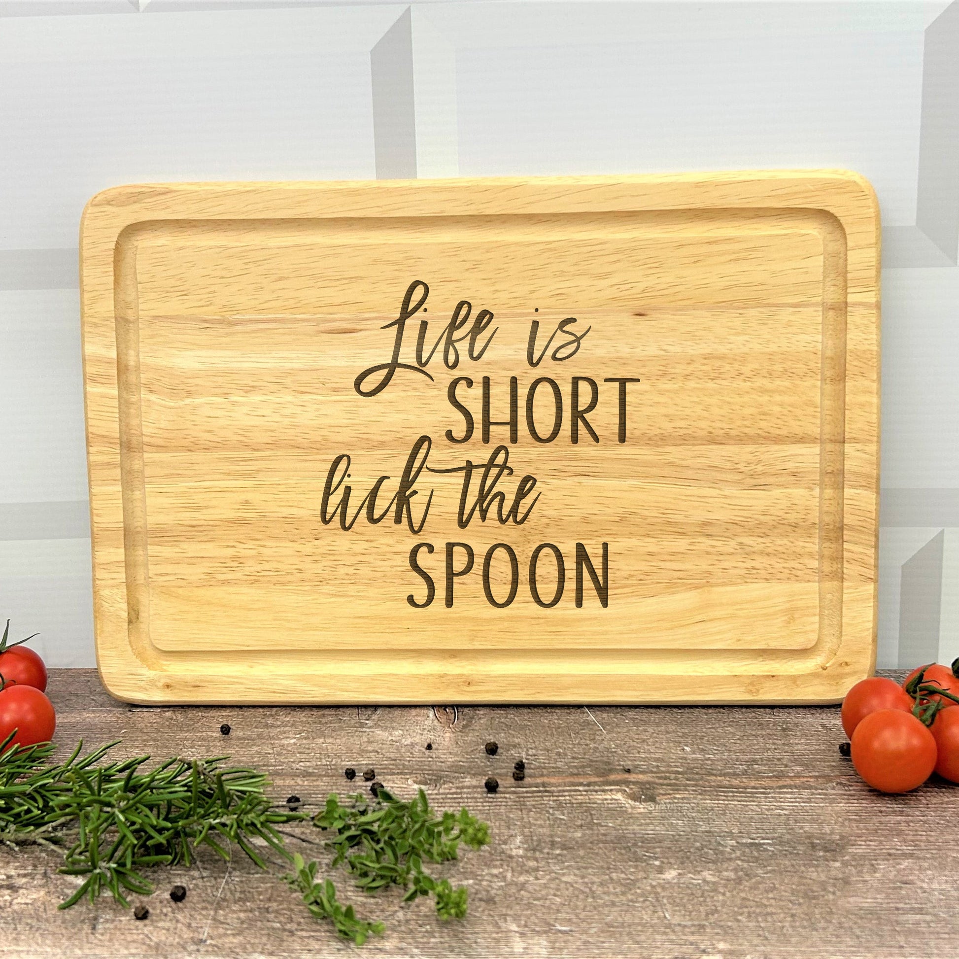 a wooden cutting board that says life is short but the spoon