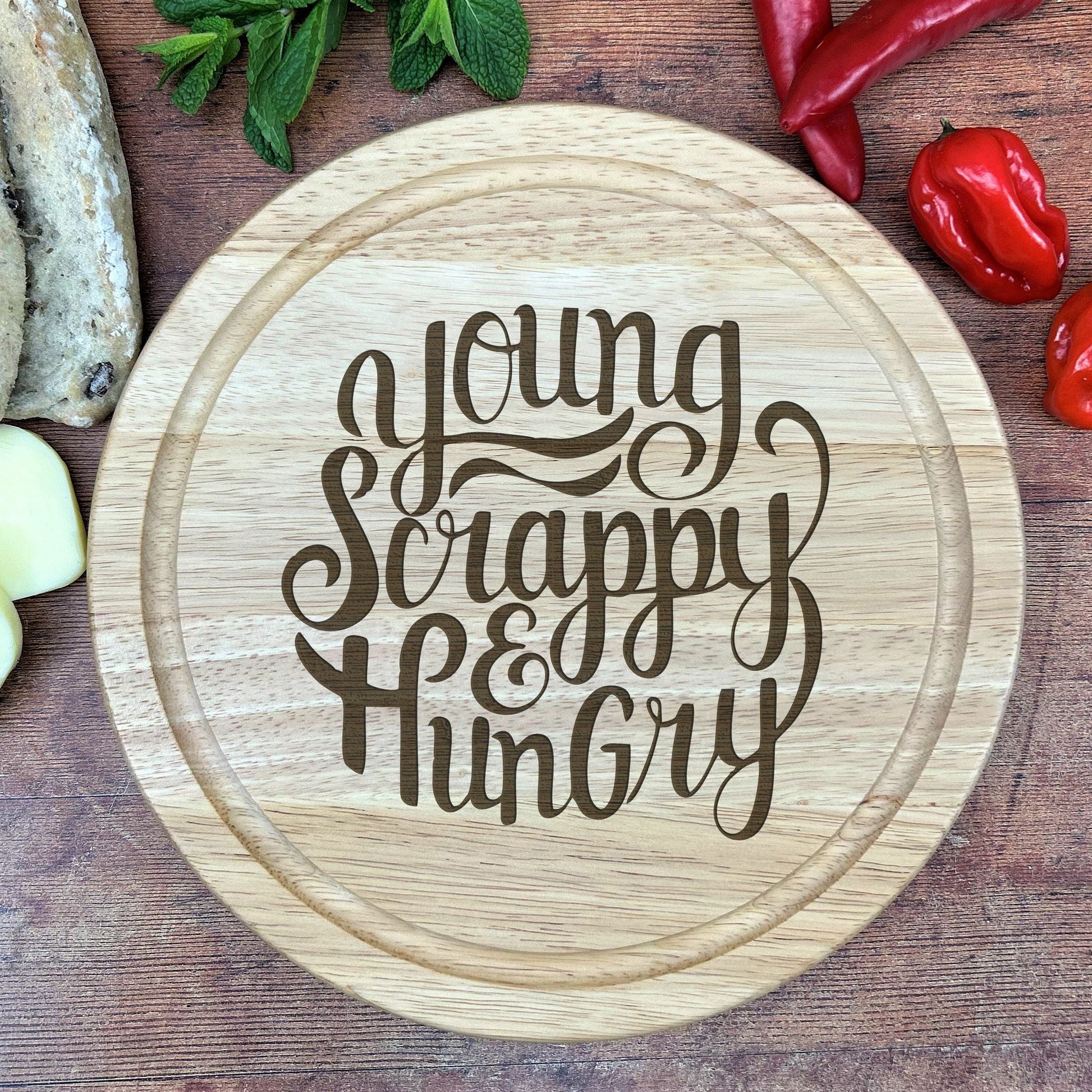 a wooden cutting board with the words young, happy, hungry on it
