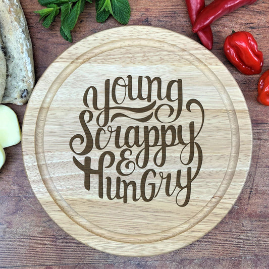 a wooden cutting board with the words young, happy, hungry on it