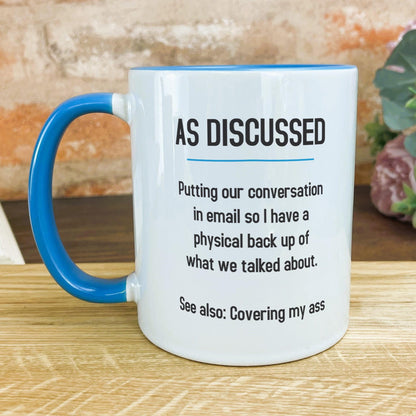 a blue and white coffee mug sitting on top of a wooden table