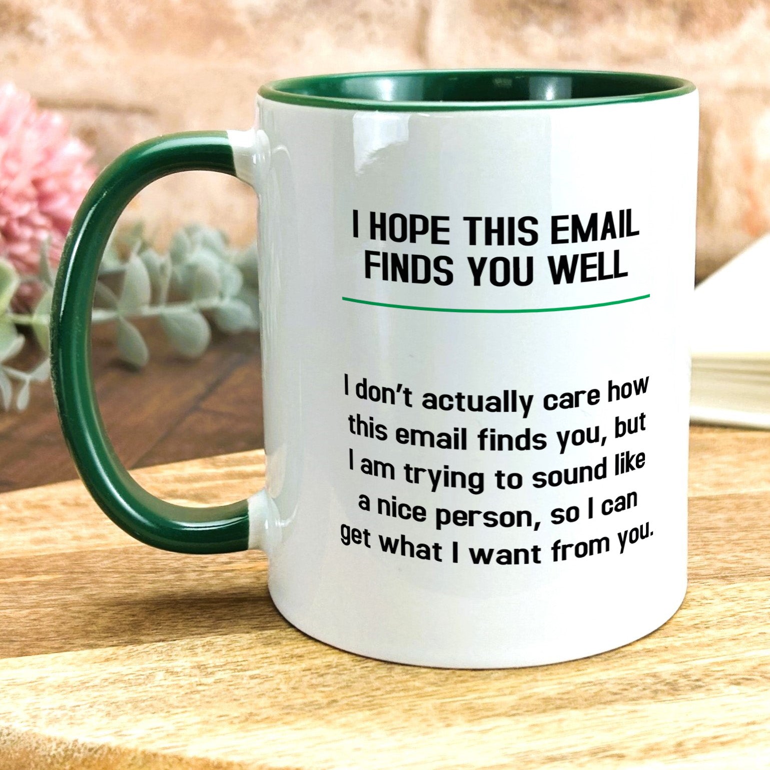a green and white coffee mug sitting on top of a wooden table
