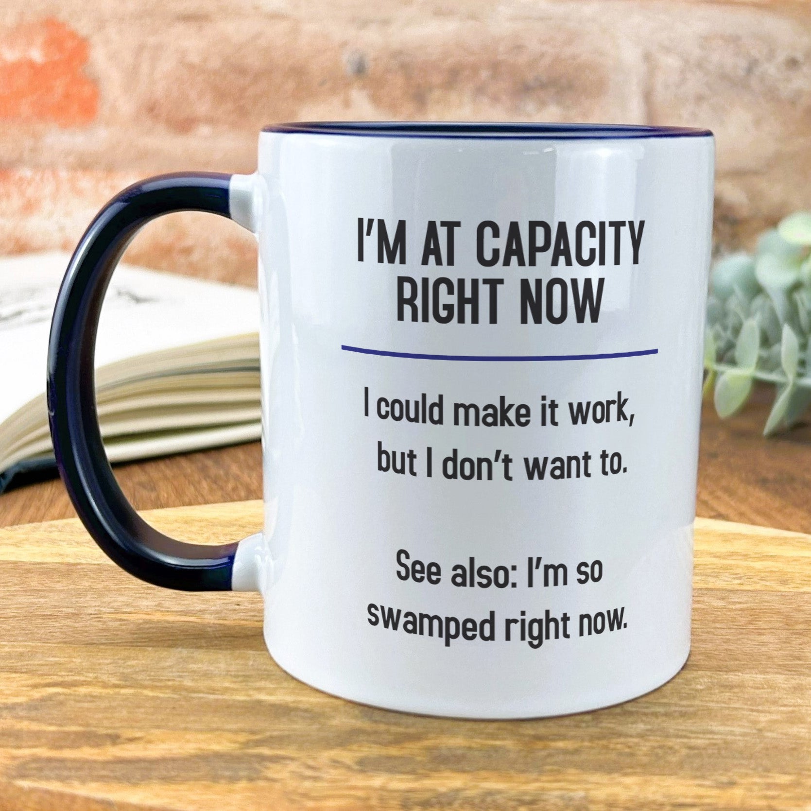 a black and white coffee mug sitting on top of a wooden table