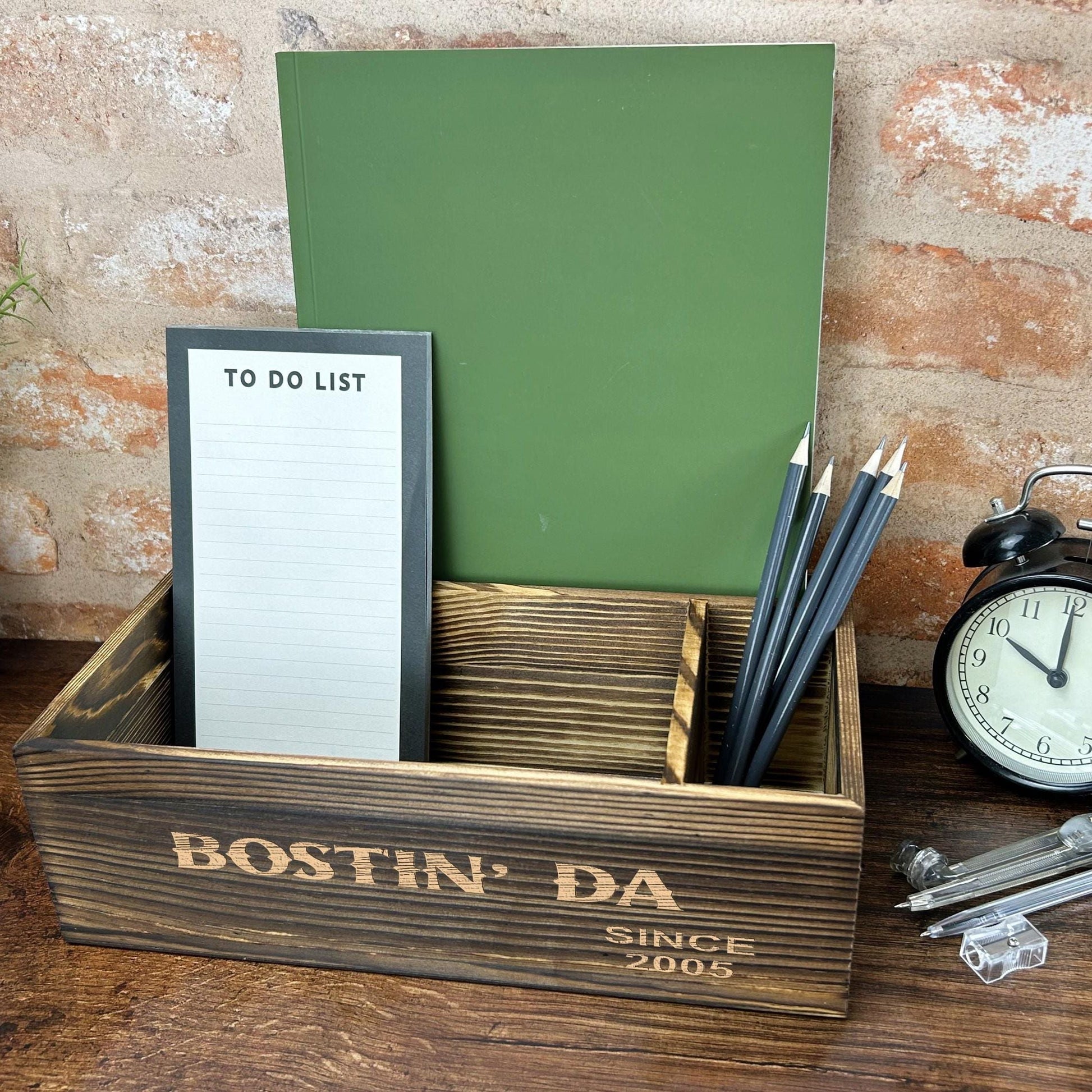 a desk with a clock, notepad, pen holder and pen