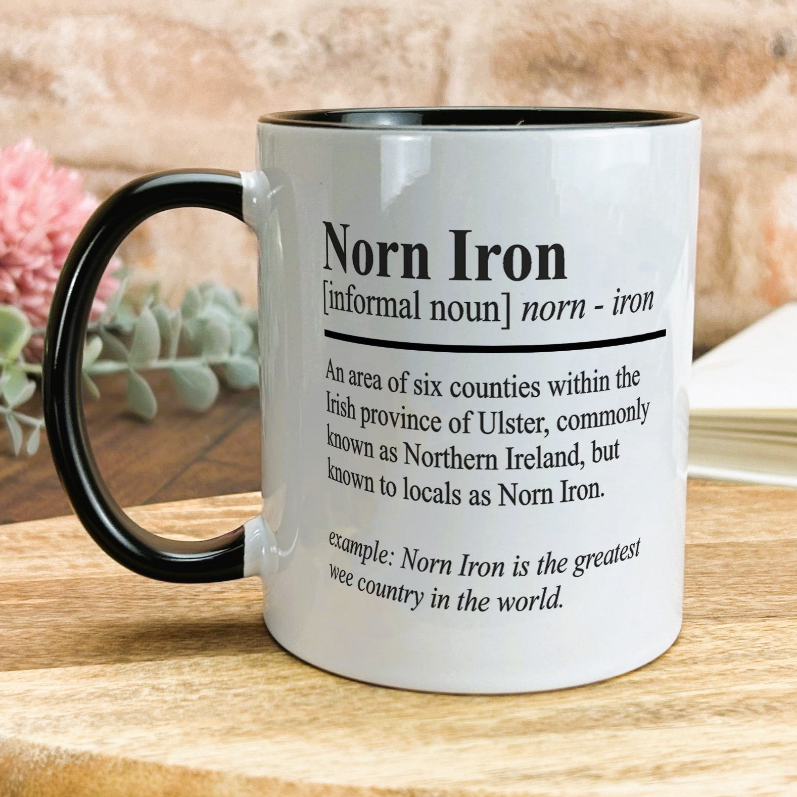 a black and white coffee mug on a wooden table