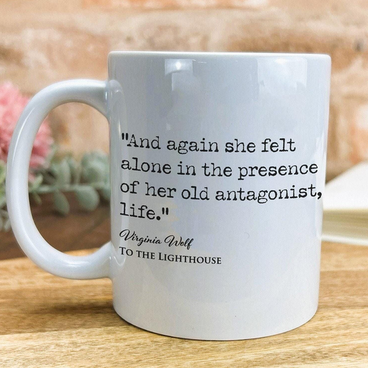 A white ceramic mug with a quote printed on it, placed on a wooden surface.