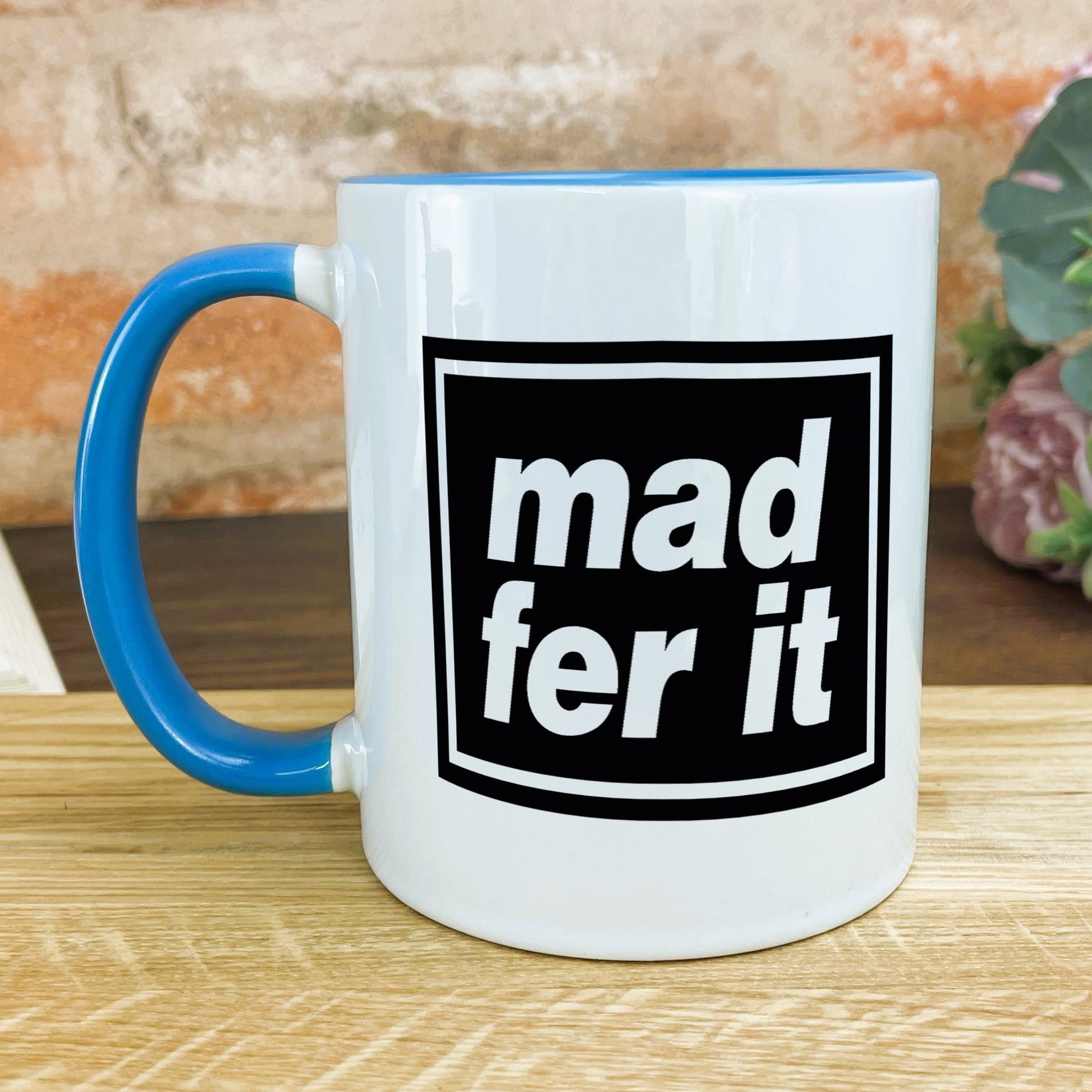 a blue and white coffee mug sitting on top of a wooden table