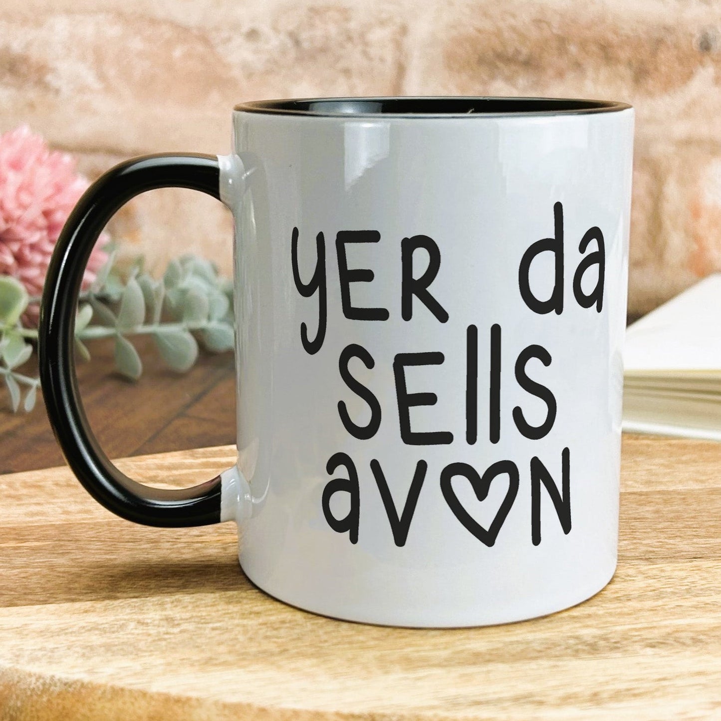 a black and white coffee mug sitting on top of a wooden table