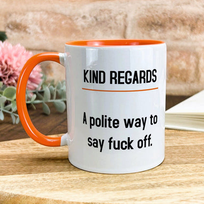 a white and orange coffee mug sitting on top of a wooden table