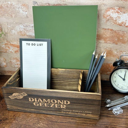 a desk with a clock, notepad, pen holder and pen