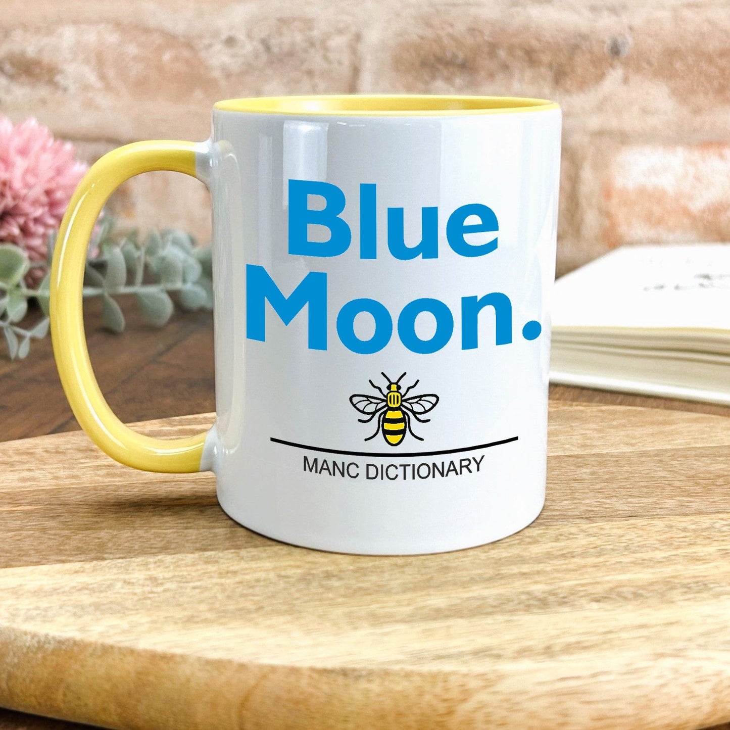 a yellow and white coffee mug with a blue moon on it