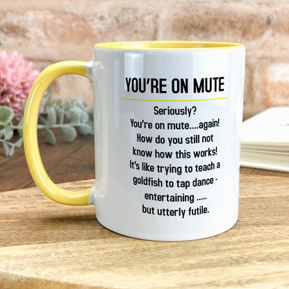 a yellow and white coffee mug sitting on top of a wooden table