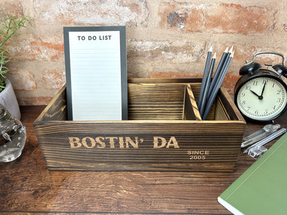 a desk with a clock, notepad and pen holder