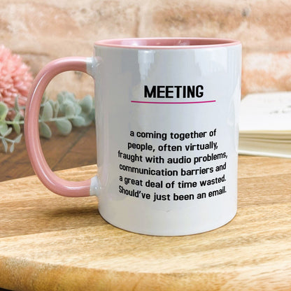 a pink and white coffee mug sitting on top of a wooden table