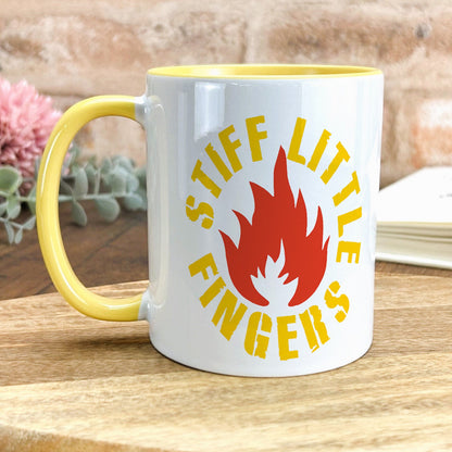 a yellow and white coffee mug sitting on top of a wooden table