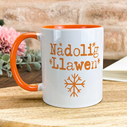 a white and orange coffee mug sitting on top of a wooden table