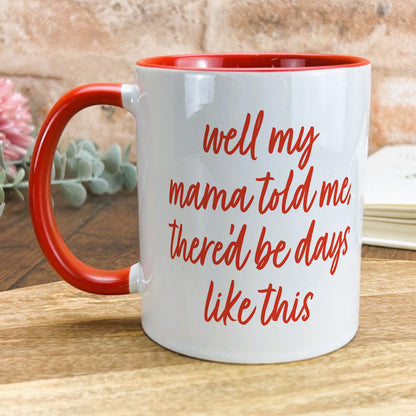 a red and white coffee mug sitting on top of a wooden table
