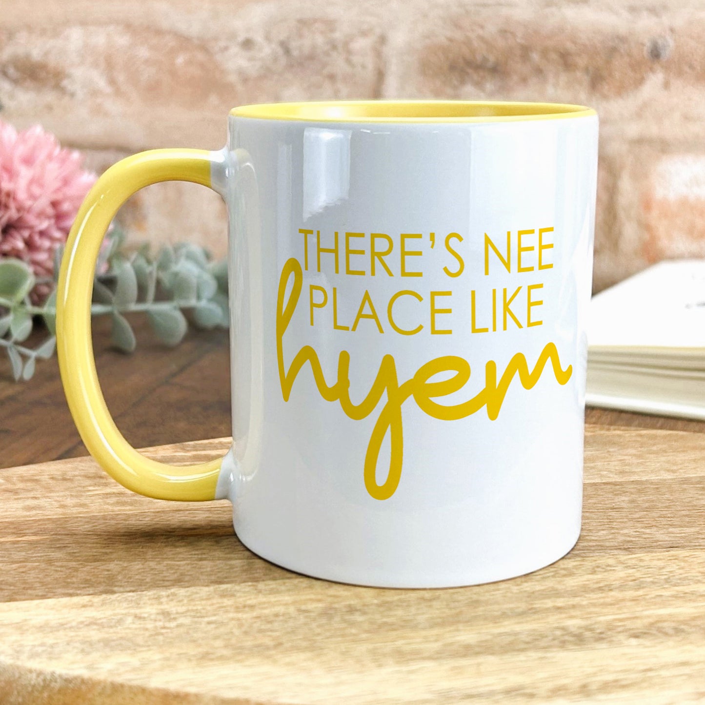a yellow and white coffee mug sitting on top of a wooden table