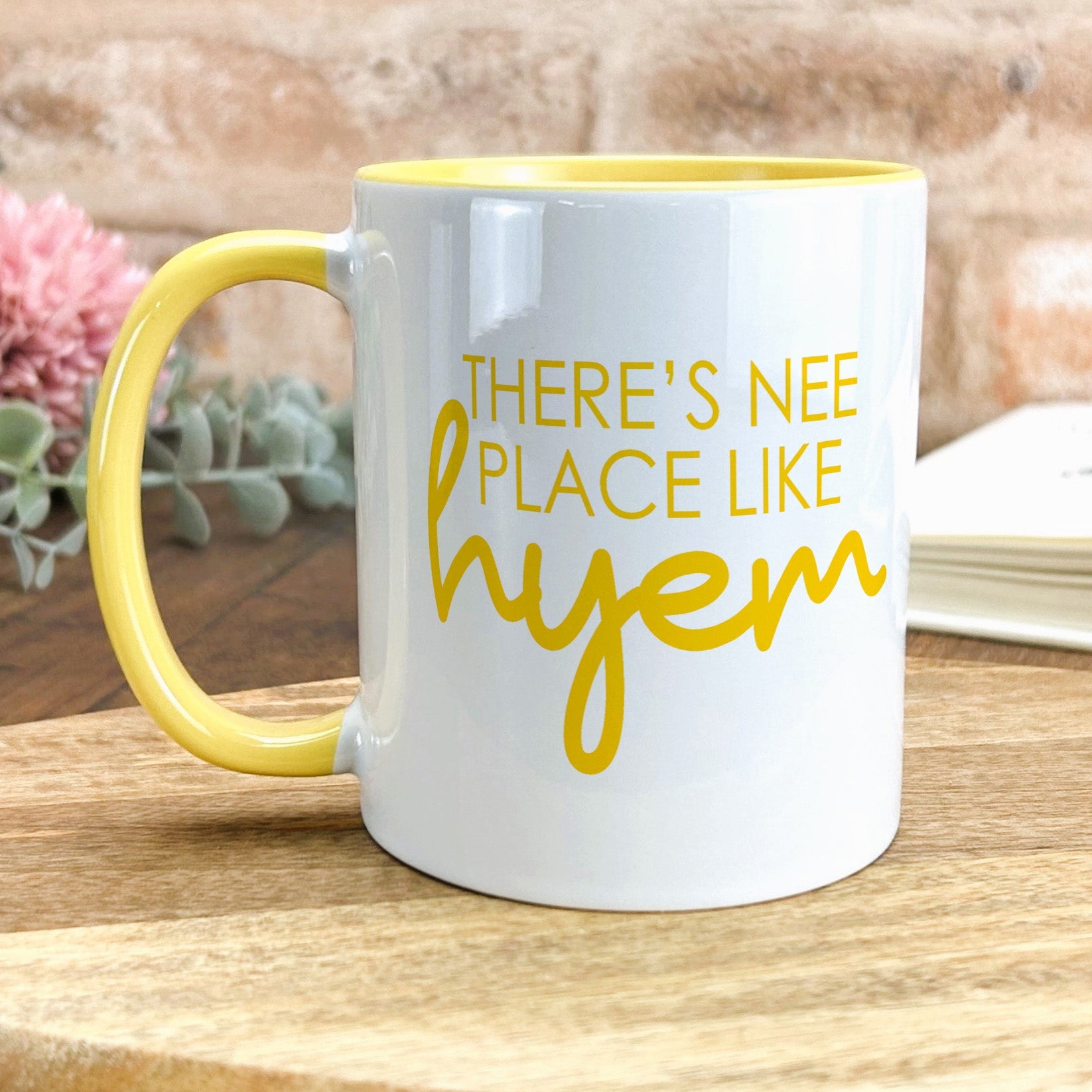 a yellow and white coffee mug sitting on top of a wooden table