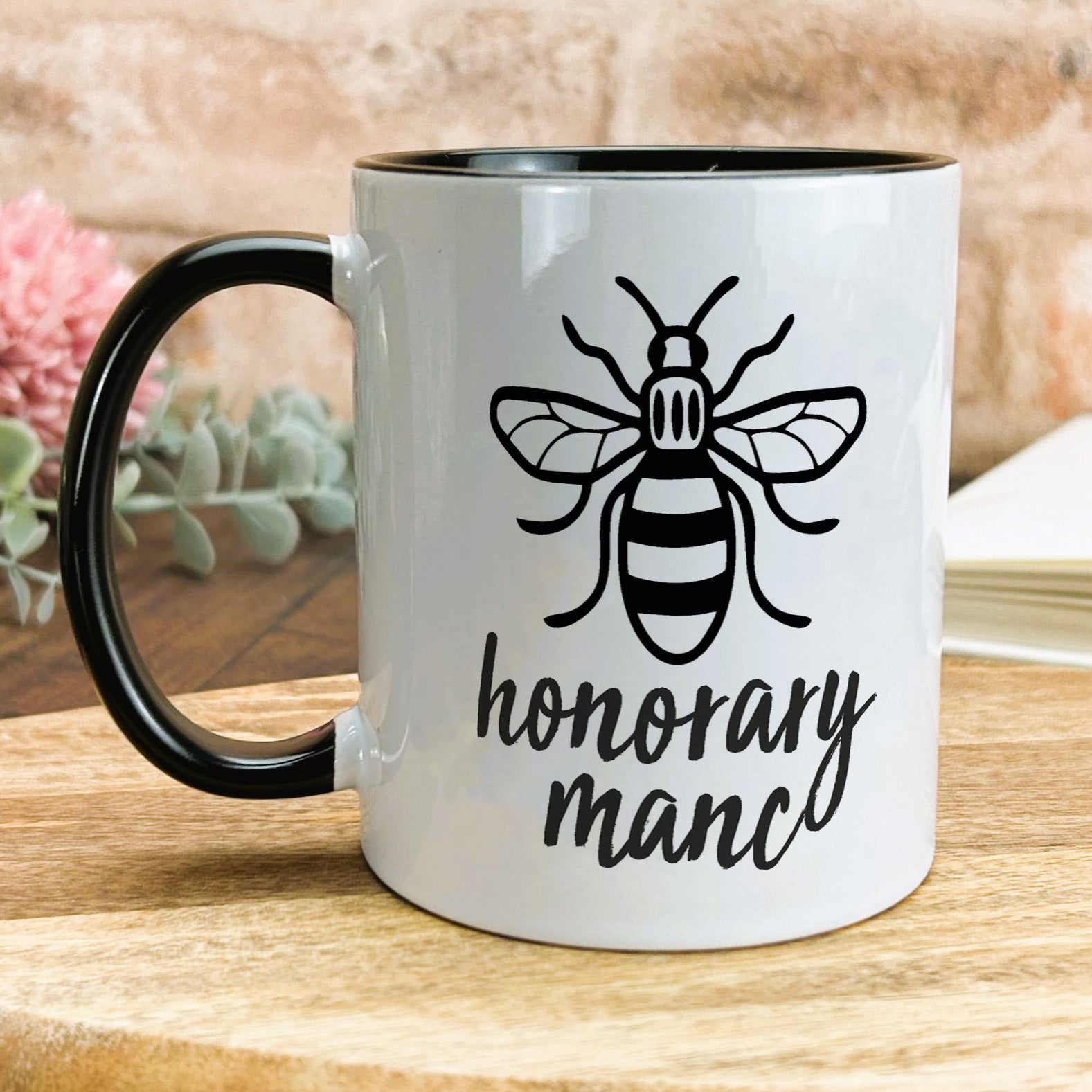a black and white coffee mug with a bee on it
