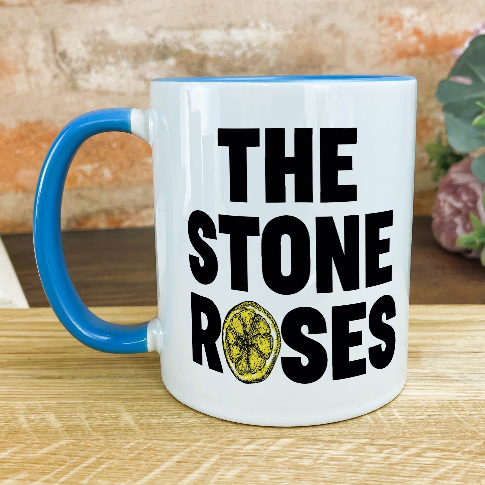 a blue and white coffee mug with the words the stone roses on it