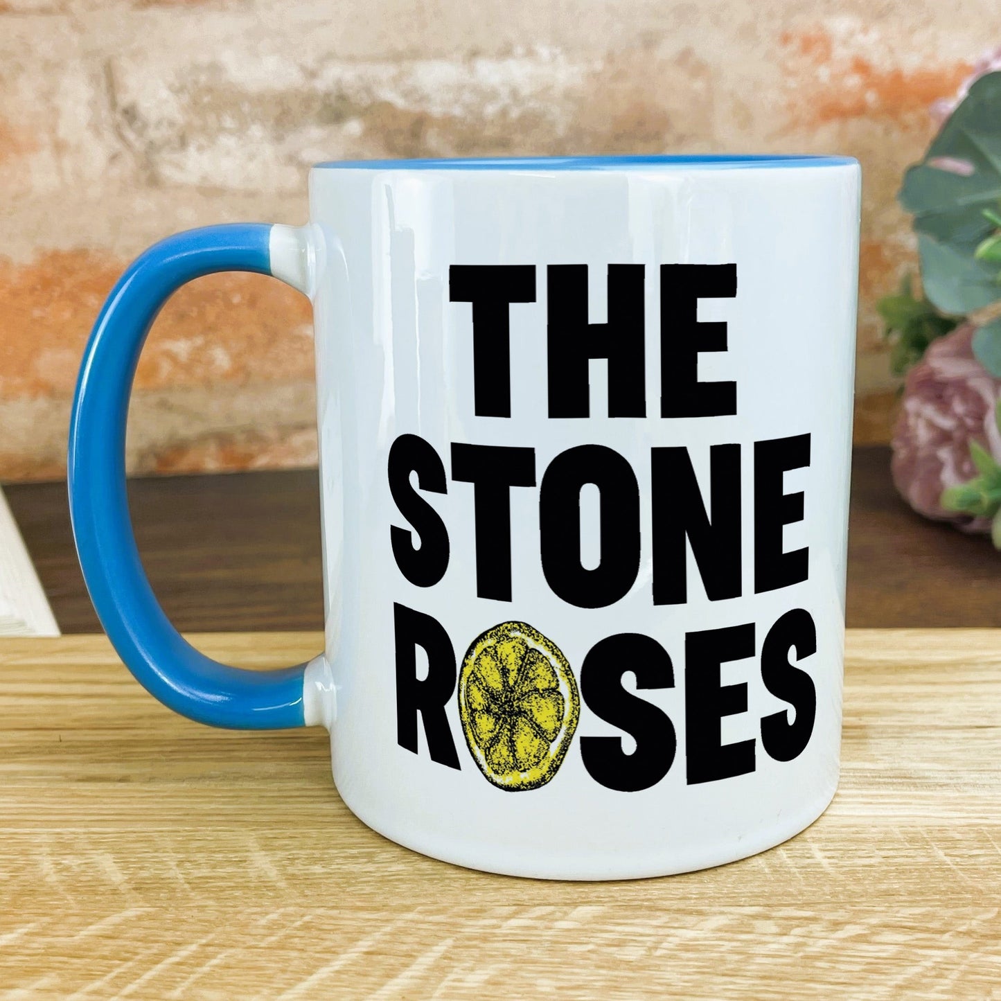 a blue and white coffee mug with the words the stone roses on it