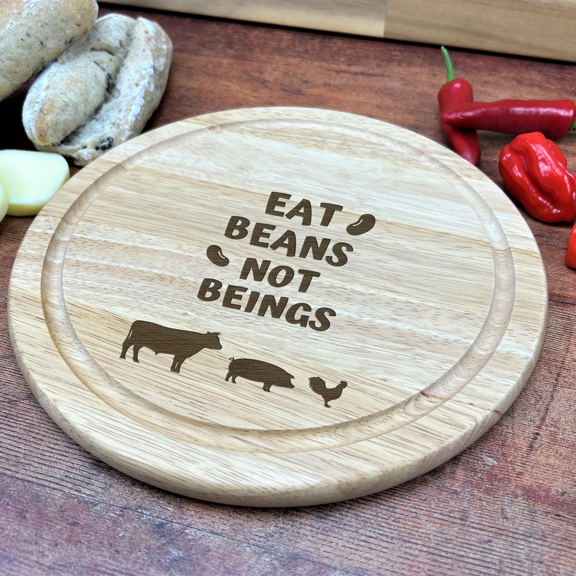 a wooden cutting board with a cutting board saying eat beans not beings