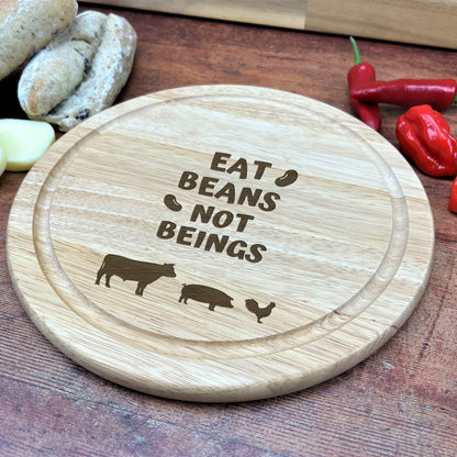 a wooden cutting board with a cutting board saying eat beans not beings