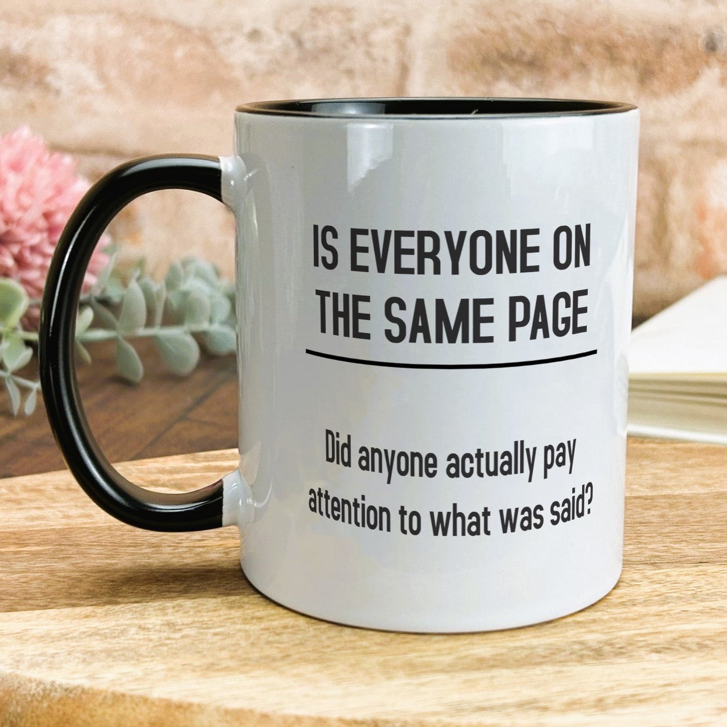 a black and white coffee mug sitting on top of a wooden table