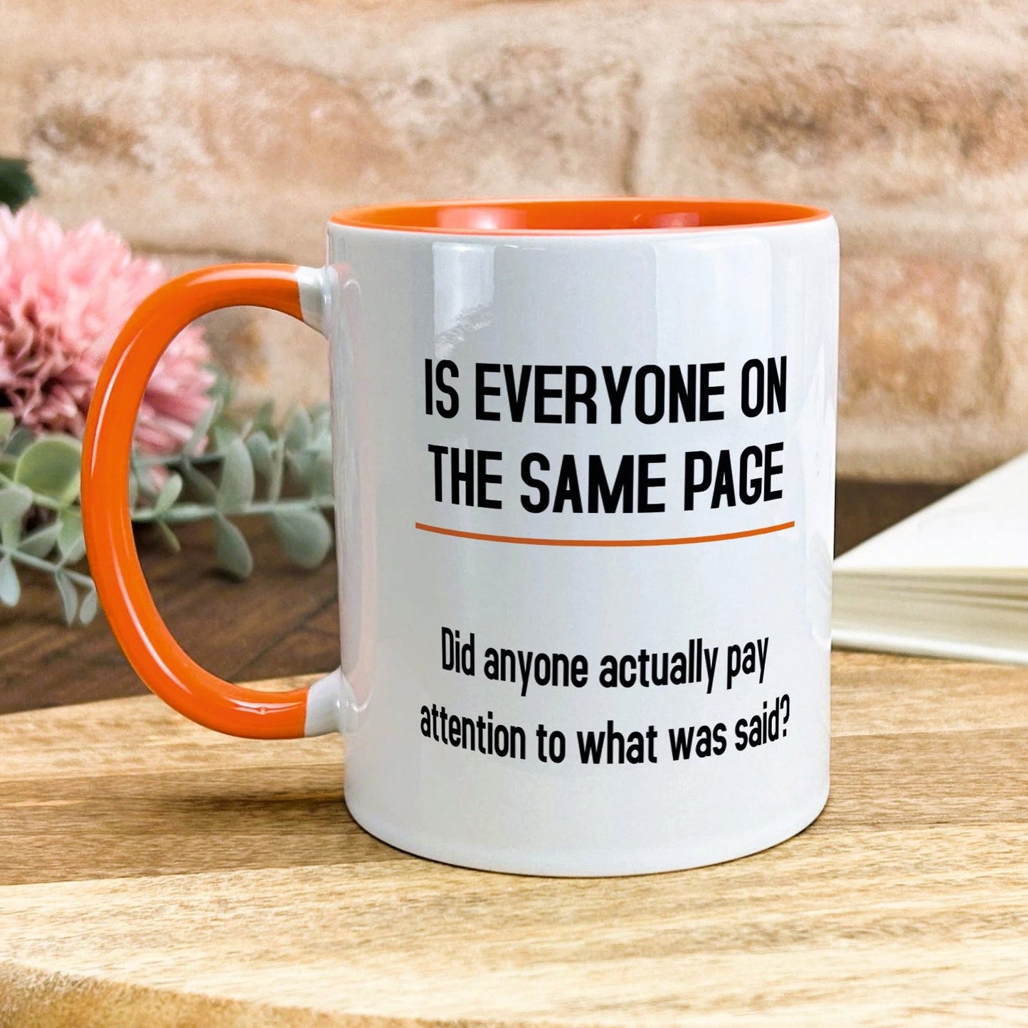 a white and orange coffee mug sitting on top of a wooden table
