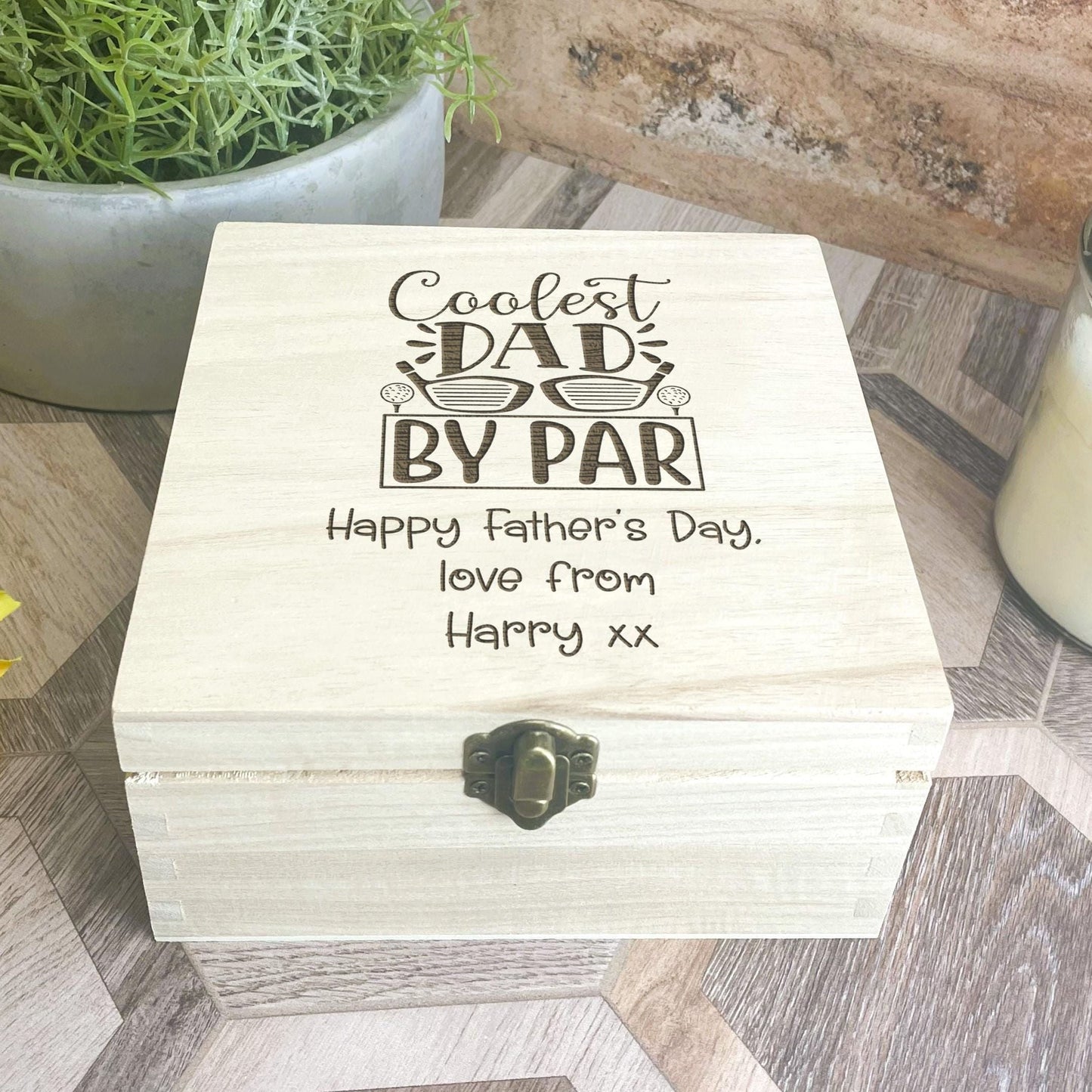 a wooden box sitting on top of a table next to a vase of flowers