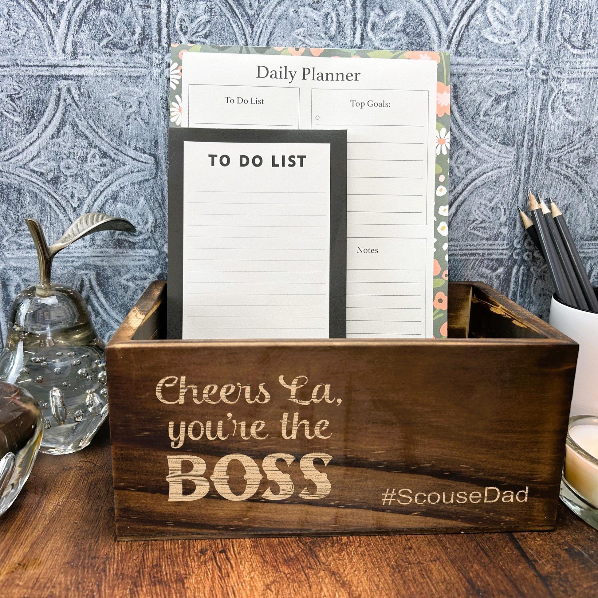 a wooden box with a notepad and a candle