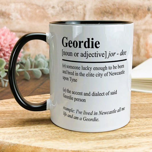a black and white mug sitting on top of a wooden table