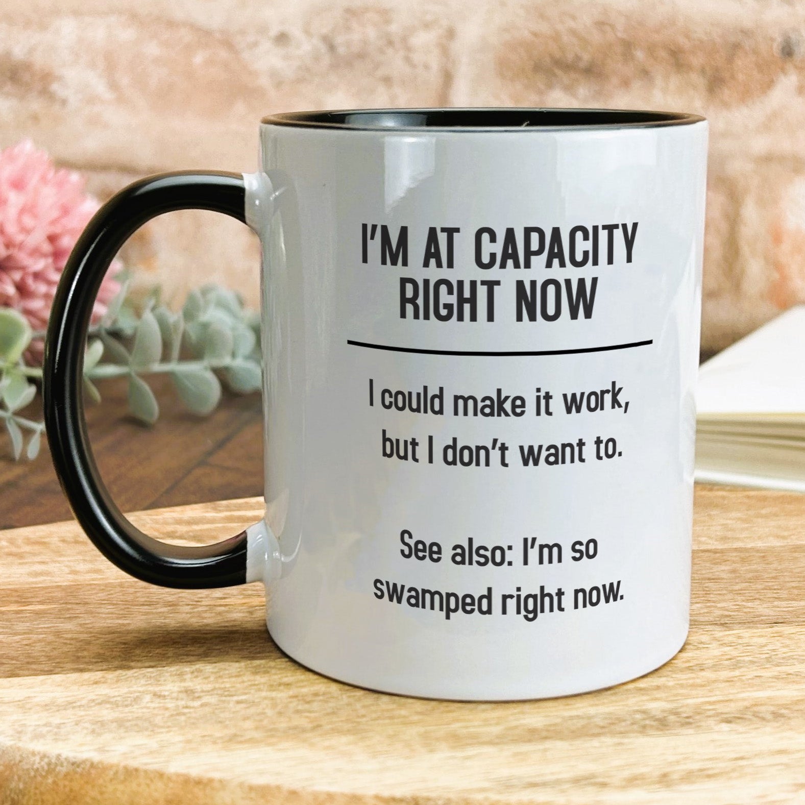 a black and white coffee mug sitting on top of a wooden table