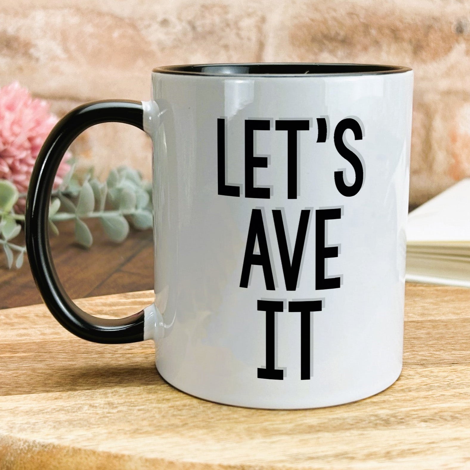 a black and white coffee mug sitting on top of a wooden table