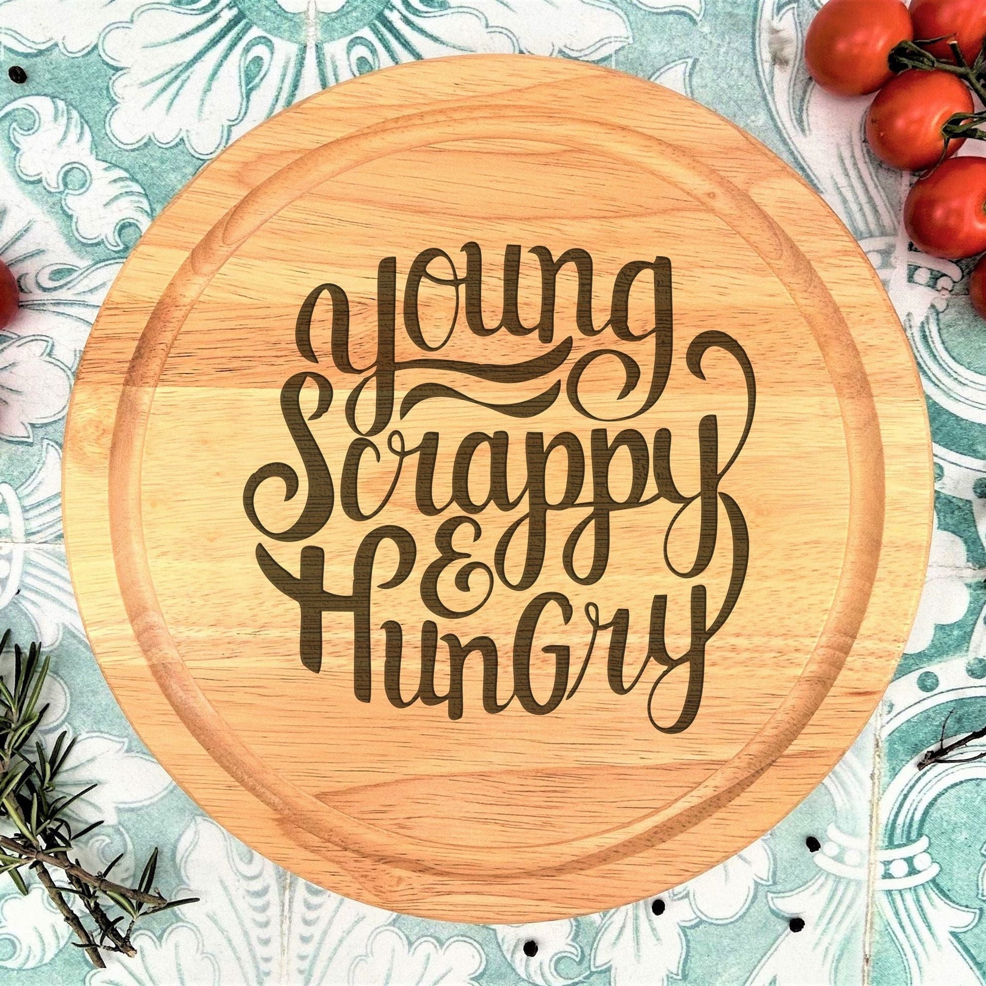a wooden cutting board with the words young, scrappy, and hungry on it