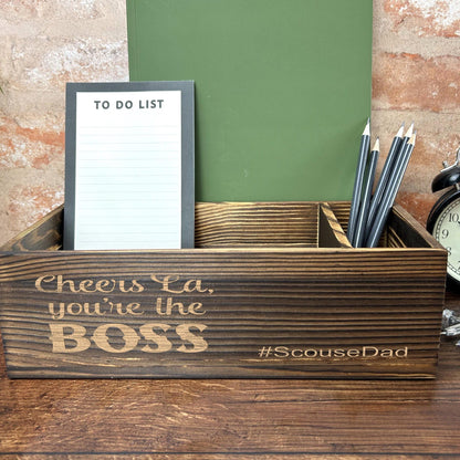 a desk with a clock, notepad and pen holder