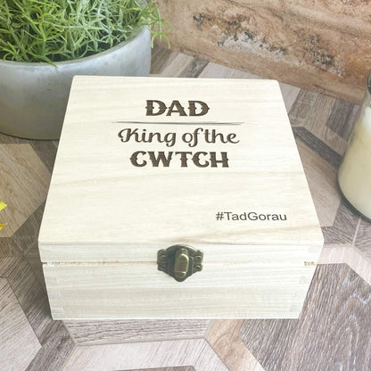 a wooden box sitting on a table next to a candle