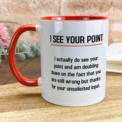 a red and white coffee mug sitting on top of a wooden table