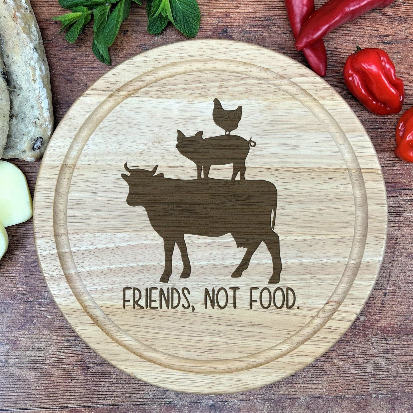 a cutting board with a picture of a cow and two chickens on it