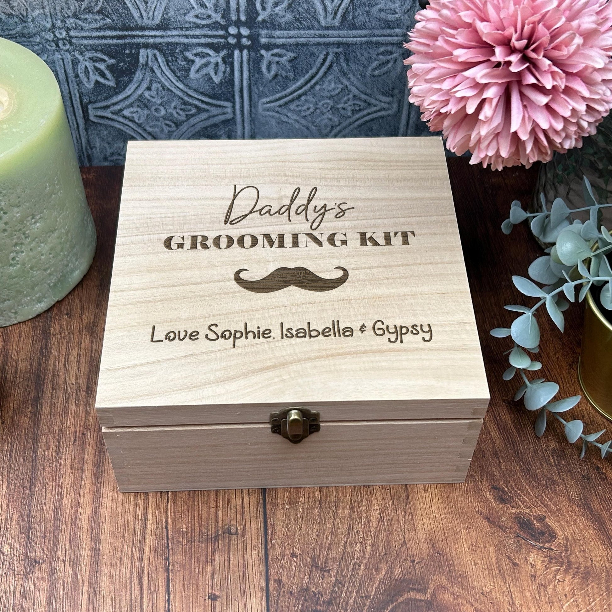 a wooden box sitting on a table next to a candle