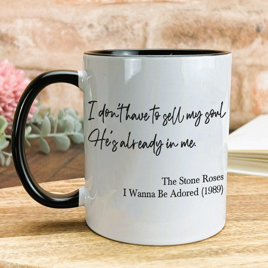 A white coffee mug with black text and a quote from the song "The Stone Roses" by The Rockettes.